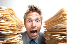 Man upset with the stacks of paper work surrounding him