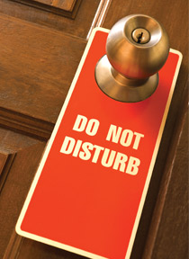 A "Do Not Disturb" notice hanging from a door knob