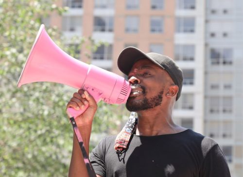 A man speaks into a megaphone at a protest