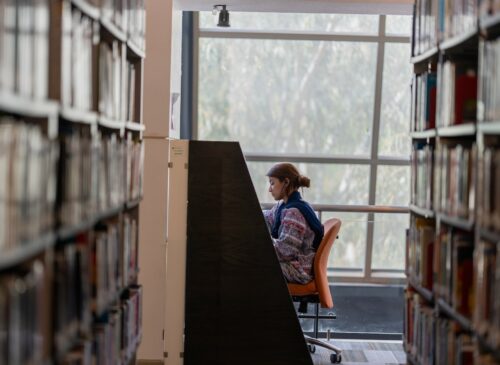 A person sits in a study carrell in a library.